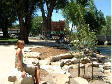 Girl sitting on rock at a whitewater park