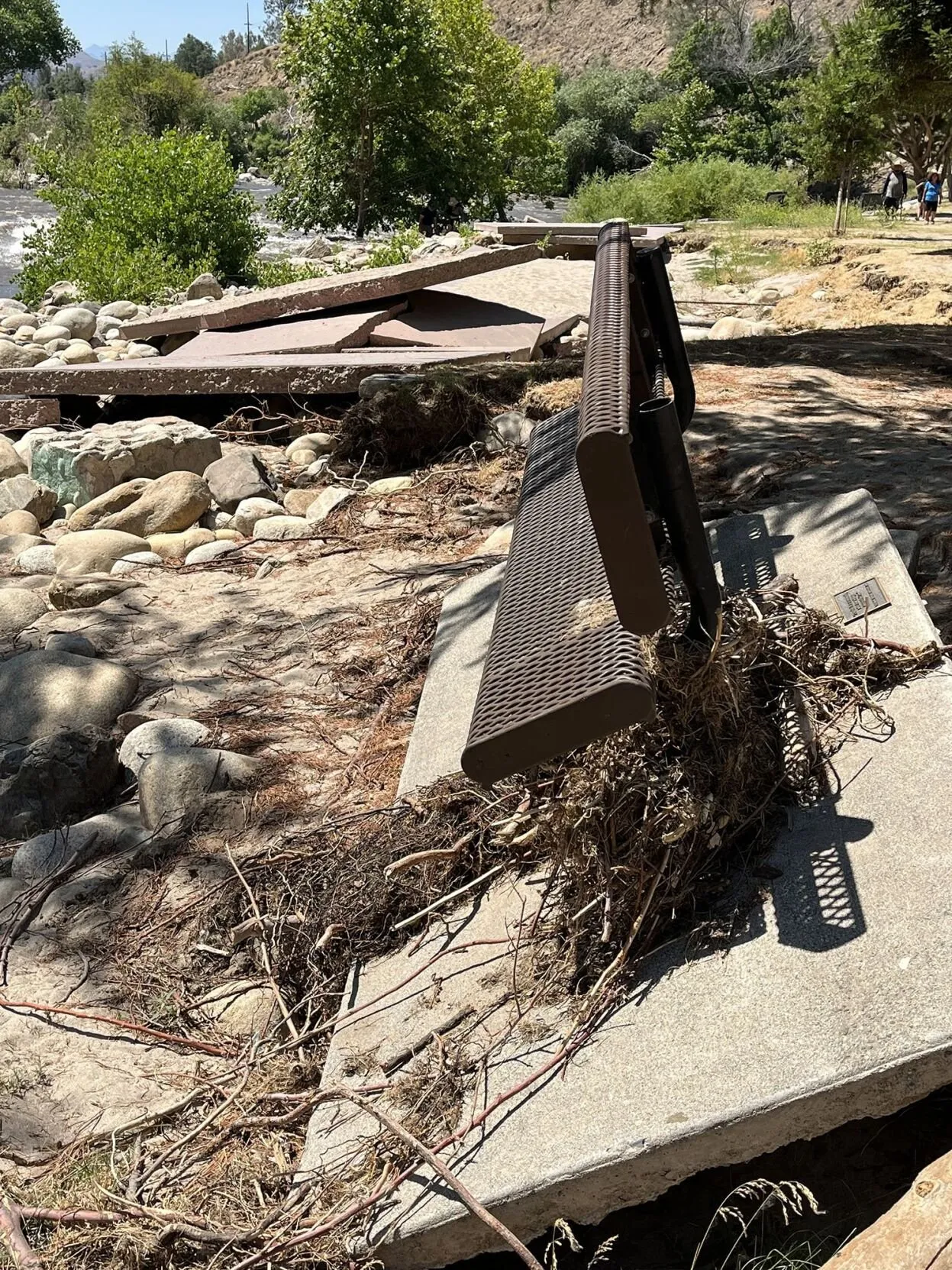 view of damaged sidewalk along Riverside Park after 2023 flooding