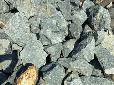 Sharp riprap rock piled along a riverbank